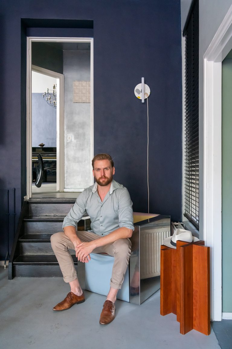 Porträtfoto von Wisse Trooster, Designer und Kurator der Isola Talents Factory. Für seine Circular Wall Lampen – an der Wand hinter ihm – verwendet er statt Terrazzo recycelte Materialien.